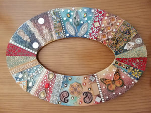 ovalerförmiger persischer Spiegelrahmen in bunten Farben und Stein Verzierungen.